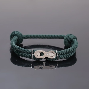 Gros plan d'un bracelet en corde tressée vert foncé avec boucle rapide en style chaîne