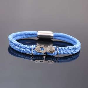 Détail du bracelet en corde tressée bleu clair avec maillon de chaîne et fermoir magnétique