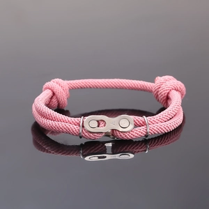 Détail macro du bracelet rose tissé avec maillon de chaîne en acier inoxydable