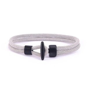 Detail eines grauen geflochtenen Armbands mit mattem schwarzem T-Verschluss und Fixierung