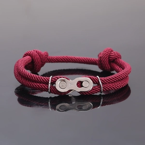 Gros plan d'un bracelet tressé bordeaux avec une boucle en forme de chaîne de vélo argent