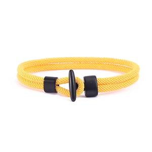 Detailaufnahme des gelben doppelt geflochtenen Armbands mit schwarzem Knebelverschluss