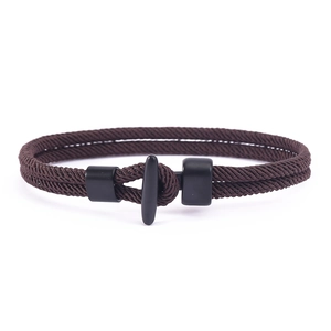 Nahaufnahme eines kaffeebraunen geflochtenen Armbands mit mattem schwarzem T-Verschluss