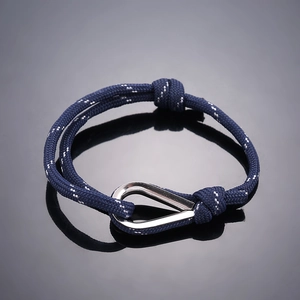 Macro shot of dark blue braided cord bracelet with silver U-shackle and reflective threads
