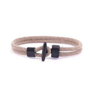 Detail eines beigen geflochtenen Seilarmbands mit schwarzem mattem Knebelverschluss
