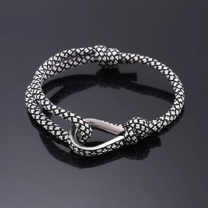 Detail of minimalist woven black and white rope bracelet with polished silver U-hook buckle