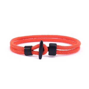 Detailaufnahme von orangefarbenem geflochtenem Armband mit mattem schwarzem T-Verschluss