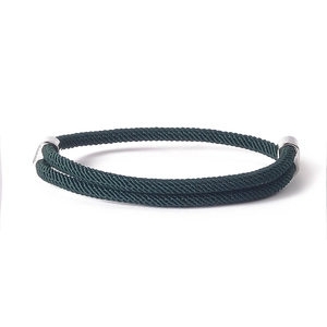 Detailed close-up of dark green braided rope bracelet with double silver metal buckles