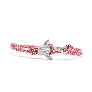 Détail du bracelet océan tressé rouge et blanc avec un pendentif requin-baleine argenté
