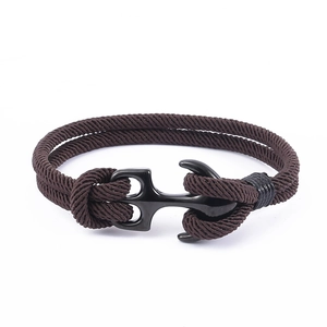 Détail d'un bracelet en corde tressée marron foncé avec fermoir ancre nautique noire mate