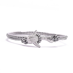 Détail du bracelet en corde tressée avec fermoir métallique en forme de requin-baleine