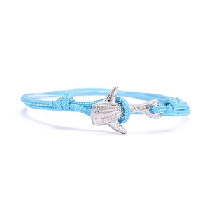 Vue macro d'un bracelet en corde tressée bleu océan avec pendentif requin-baleine argenté
