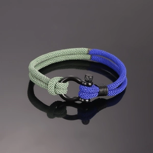 Detail van een nautische gevlochten armband met groen en blauw touw en zwarte U-sluiting