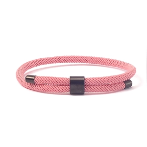 Detail van roze dubbellaags gevlochten armband met een zwarte magnetische gesp