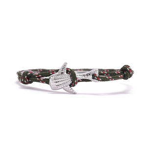 Détail du bracelet nautique tressé avec breloque requin-baleine en argent et cordon vert