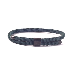 Detail van de donkergroene gevlochten touwarmband met zwart metalen schuifregelaar