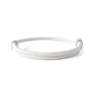 Macro detail of hand-woven white cord bracelet with polished silver magnetic clasp