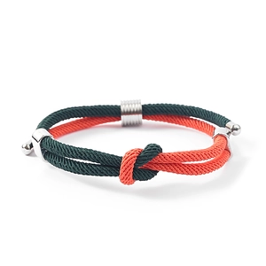 Detail van groen en oranje gevlochten armband met zilveren metalen sluiting op wit