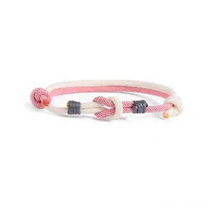 Dettaglio di un braccialetto fatto a mano con nodo concentrico in rosa e bianco