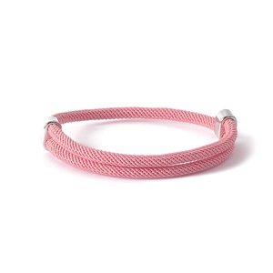 Detailed macro view of pink braided rope bracelet with polished silver metal clasps