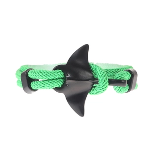 Detail of green nylon braided rope bracelet with a matte black manta ray metal charm