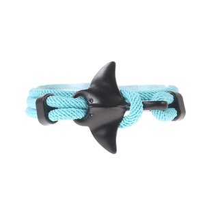 Detail of the sky blue braided cord bracelet with a black manta ray shaped metal clasp