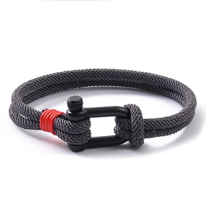 Détail du bracelet en corde milanaise grise avec manille en U noire et accent rouge vif
