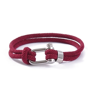 Detail of red woven double-cord bracelet featuring a silver U-shaped metal shackle clasp