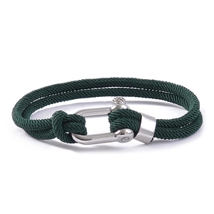 Detail of dark green double-braided cord bracelet with silver U-shaped shackle clasp
