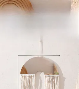 Detailed view of bohemian macrame wall decor with gold semi-circle and ivory cotton tassels