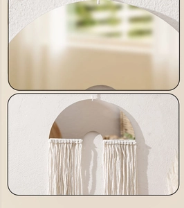 Detail of bohemian handmade macrame wall mirror with soft cotton tassels on white wall
