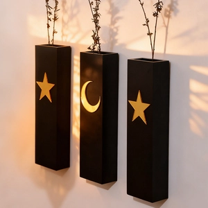Close-up of three black wooden moon and star wall shelves with golden celestial patterns