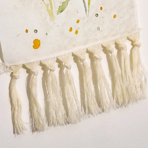 Close-up of bohemian woven tapestry with fringe and abstract plant print details