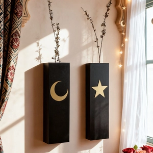 Detail of black wooden wall planters with gold celestial moon and star print designs