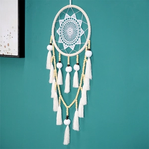 Détail d'un attrape-rêves blanc avec pompons faits main et perles en bois naturel