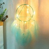 Close-up of bohemian dream catcher with LED lights and soft blue hanging feathers