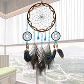 Detailed view of handmade unicorn dream catcher with peacock feathers and blue beads