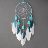 Détail de l'attrape-rêves artisanal avec fils bleu ciel et plumes naturelles douces