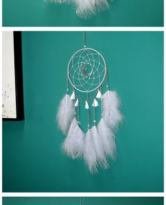 Detalle de un atrapasueños con colgante de luna plateada y suaves plumas blancas