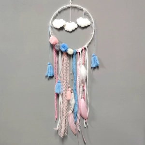 Detailed view of handmade dreamcatcher with soft feathers and pastel tassels for wall decor