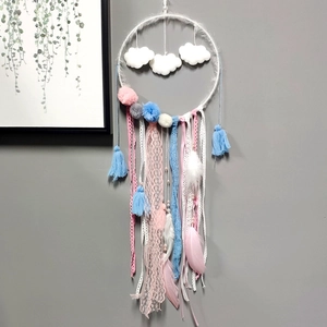 Detail of dream catcher with macaron feathers and cloud decor on a gray wall