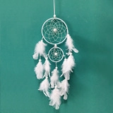Détail d'un attrape-rêves blanc bohème avec plumes souples et maillage tissé à la main
