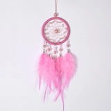 Détail d'un attrape-rêves rose avec plumes douces, filet tissé et perles élégantes