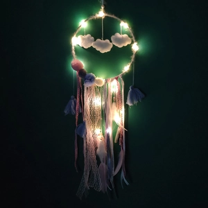 Close-up of lighted macaron dream catcher with clouds, colorful pom-poms, and soft feathers