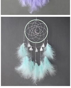Detalle de atrapasueños verde menta con colgante de luna y plumas delicadas