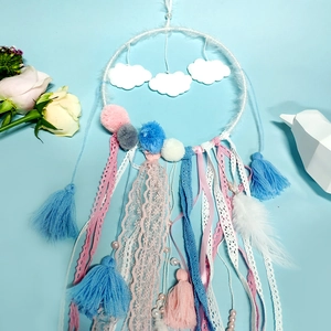 Detail of dream catcher with plush clouds, lace ribbons and soft colorful pom-poms