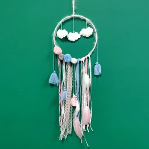 Detail of dreamcatcher with white felt clouds, colorful lace ribbons and soft feathers