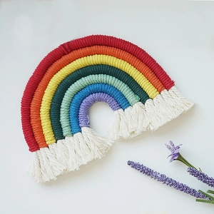 Detail of handmade bohemian rainbow tapestry with multi-color cotton ropes and white tassels