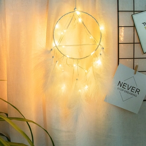 Handmade dream catcher wall hanging with white feathers and warm LED string lights decor