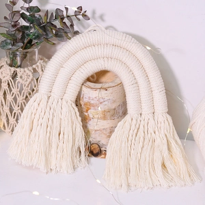 Detail of boho woven rainbow wall hanging with three layers and soft cotton tassels
